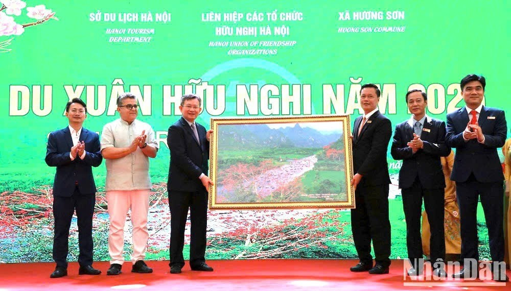 Des représentants de la commune de Huong Son offrent à la délégation une peinture représentant le ruisseau Yen, située dans le complexe historique de Huong Son. Photo : NDEL.