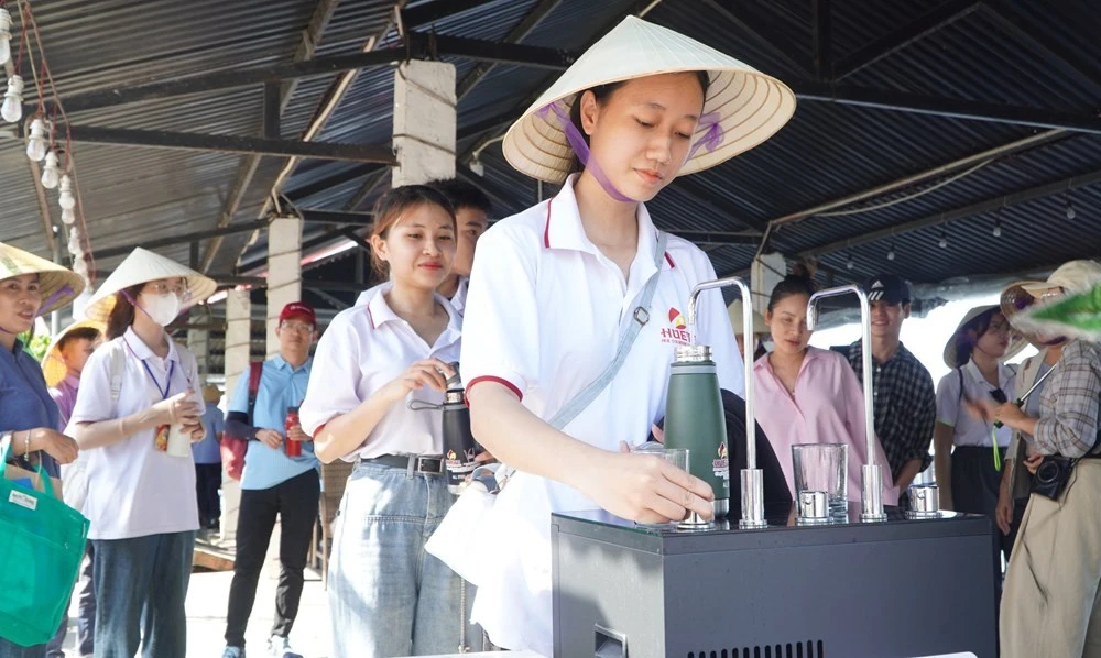 Les touristes utilisent leurs gourdes personnelles pour se ravitailler en eau dans les établissements de services à Ngu My Thqnh – Con Toc, dans le but de réduire les déchets plastiques. Photo: bvhttdl.gov.vn 