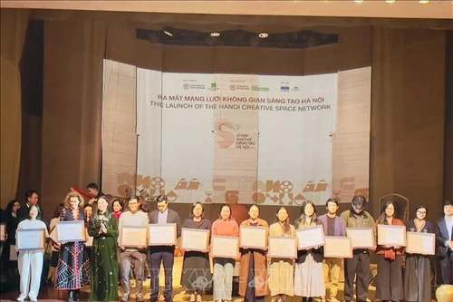 La directrice du Département de la Culture et des Sports de Hanoï, Mme Bach Lien Huong (3e, gauche), remet le certificat d'espace culturel créatif de Hanoï aux représentants des espaces culturels créatifs. Photo : VNA.