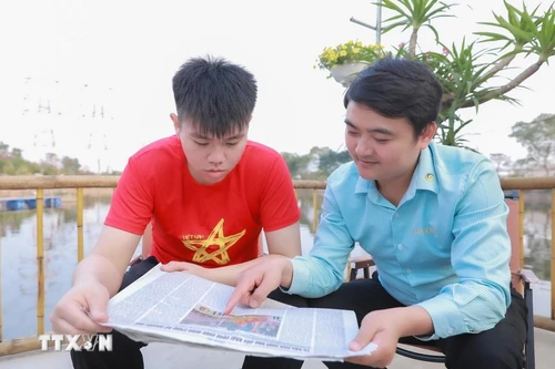 Des jeunes du Groupe 4 (rue Tinh Quang, quartier de Viet Hung, Hanoï) s’informent sur le XIVe Congrès du Parti via la presse, exprimant leur confiance dans la réussite du Congrès. Photo : VNA