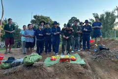 L’équipe de recherche et de rapatriement, accompagnée des forces compétentes et d’habitants laotiens, se recueille devant les restes de soldats tombés au combat retrouvés au Laos. Photo : baodantri.