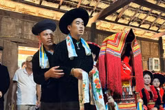 Les mariés dao rouge se tiennent devant l’autel des ancêtres, tandis que le maître de cérémonie et ses deux assistants accomplissent les rites pour le mariage. Photo : Vietnamnet.