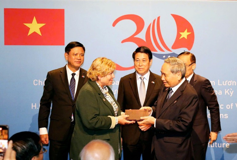 Le président vietnamien Luong Cuong (au milieu) assiste à la cérémonie de restitution des souvenirs de guerre aux vétérans américains et à leurs familles. Photo : NDEL.