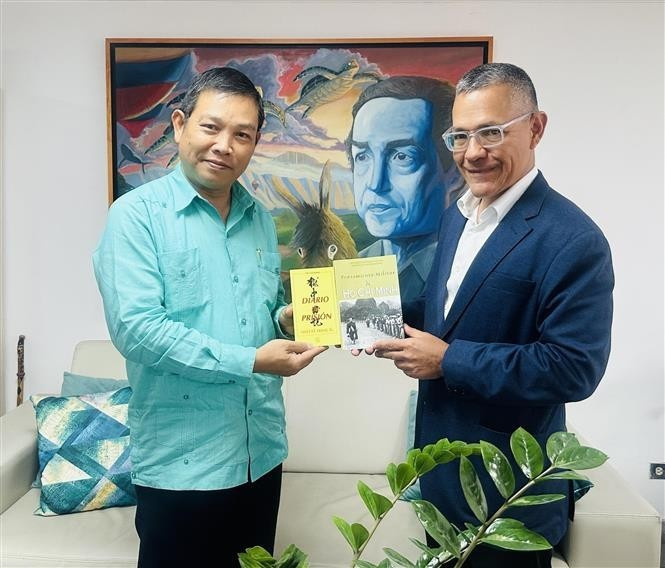 L'ambassadeur vietnamien Vu Trung My (gauche) offre au ministre de la Culture Ernesto Villegas plusieurs œuvres représentatives du Président Ho Chi Minh. Photo : VNA.