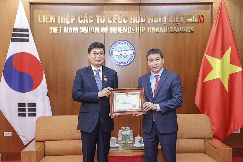 Le président de l’Union des organisations d’amitié du Vietnam, Phan Anh Son (à droite), remet l’insigne « Pour la paix et l’amitié entre les peuples » au président du Conseil d’administration de la société par actions DK ENC Vietnam, Jang Chin Hyuk. Photo : Thoidai.