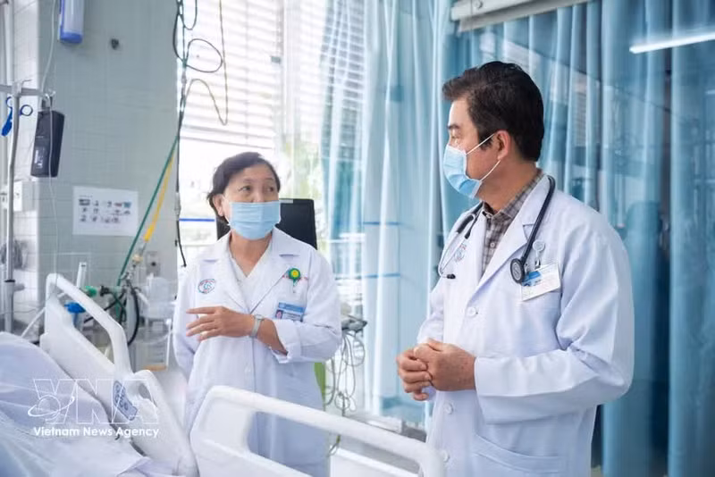 Deux spécialistes de l'hôpital Cho Ray examinent les options thérapeutiques pour la victime. Photo : VNA.