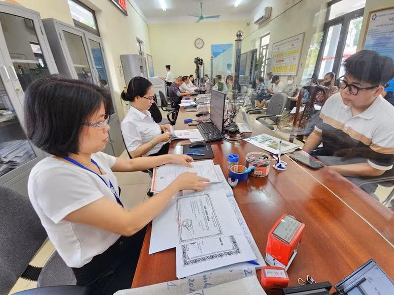 Des habitants effectuent des démarches administratives au Centre de services administratifs publics de la commune de Thien Loc, à Hanoï. Photo : journal Tin tuc et Dan toc.
