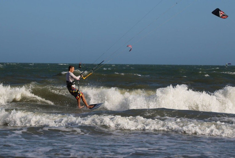 Des touristes internationaux font du kitesurf sur la plage de Mui Ne, au Centre du Vietnam. Photo : VNA.