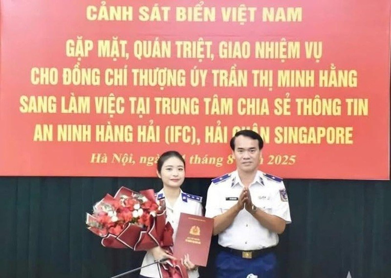 Le général de division Vu Trung Kien, commandant adjoint chargé des affaires juridiques de la Garde-côte du Vietnam, remet la décision à la lieutenante Tran Thi Minh Hang. Photo : La Duy.