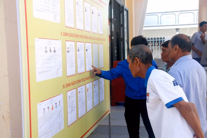 Des électeurs issus des minorités ethniques de la commune de Bac Binh (Lâm Dông) consultent les biographies des candidats avant le jour du scrutin. Photo : VNA.