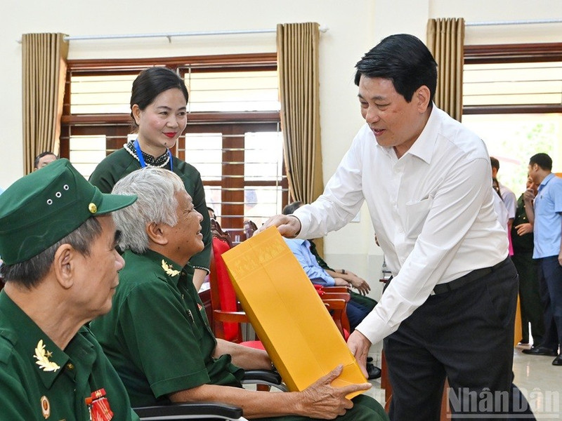 Le président Luong Cuong remet des cadeaux aux invalides de guerre hébergés au Centre de soins aux invalides de guerre de Duy Tien. Photo : NDEL.