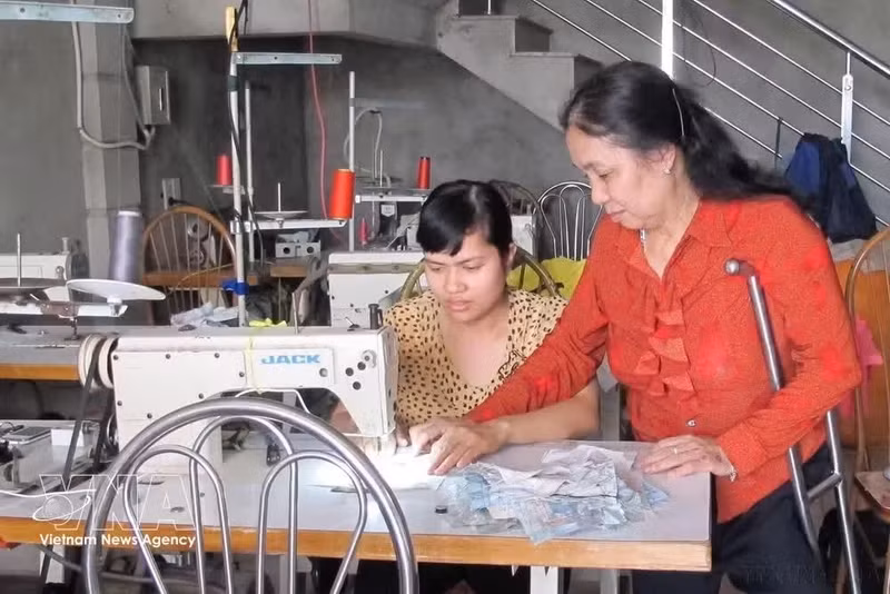 Nguyen Thi Hoa, propriétaire d'un atelier de confection situé dans la province de Ninh Binh, est une personne handicapée. Depuis des décennies, son atelier a formé des milliers d'ouvriers du textile, dont environ 500 personnes handicapées. Photo : VNA.