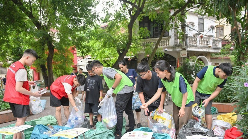 À Hanoï, les membres du groupe Tagom guident les habitants dans le tri des déchets. Photo : NDEL.