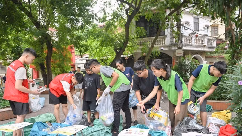 À Hanoï, les membres du groupe Tagom guident les habitants dans le tri des déchets. Photo : NDEL.