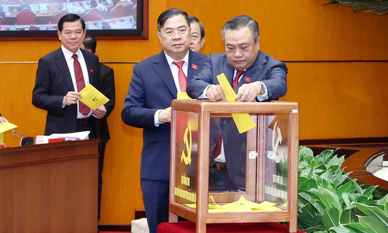 Les délégués procèdent au vote lors du premier plénum du Comité central du Parti du XIVe mandat, dans la matinée du 23 janvier. Photo : VNA.