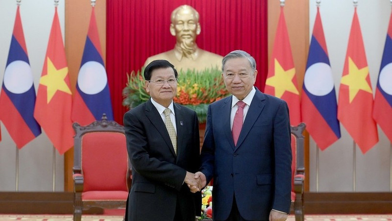 Le secrétaire général du Parti communiste du Vietnam, To Lam (droite) rencontre le secrétaire général du Parti révolutionnaire populaire lao et président du Laos, Thongloun Sisoulith, à l'occasion de sa participation à la cérémonie de signature de la Convention des Nations Unies contre la cybercriminalité à Hanoï. Photo : Dang Khoa.
