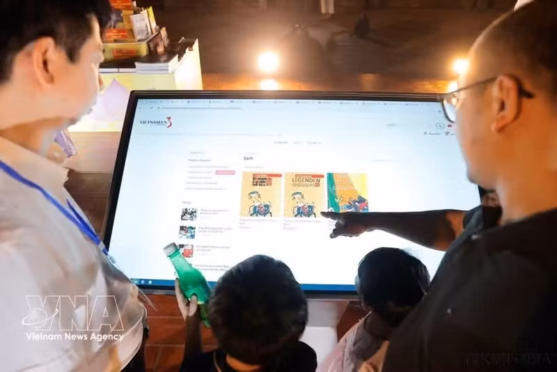 Des visiteurs découvrent l'application de livre électronique. Photo : VNA.