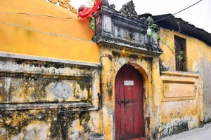 Le portail d’une maison datée de 1929, couvert de mousse et marqué par les fissures du temps, nécessite des mesures de relevé, de consolidation et une protection efficace contre l’humidité. Photo : hanoimoi.vn