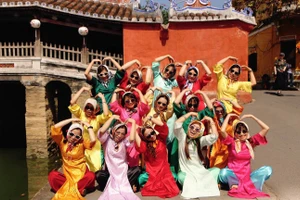 Mme Mai et son groupe d’amies prennent des photos au site patrimonial du Pont japonais. Photo : tienphong.vn