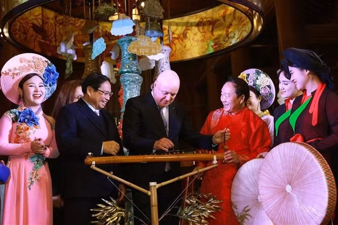 Le Premier ministre néo-zélandais Christopher Luxon découvre le đàn bầu, un instrument de musique vietnamien fabriqué en bambou. Photo : VNA.