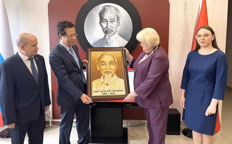 L’ambassadeur Dang Minh Khôi (2e, à gauche) a offert à la rectrice de l’école No 488, Natalia Osennova, un portrait de l’Oncle Hô fait à base de grains de riz. Photo : VOV.