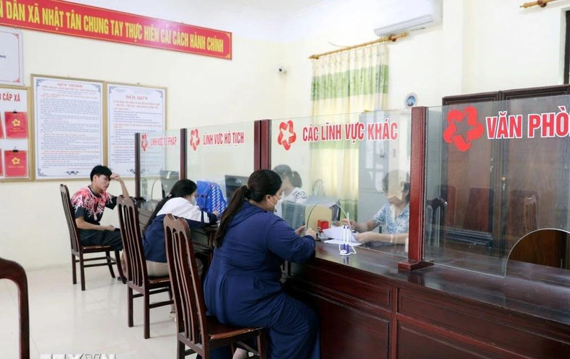 Des gens effectuent des démarches administratives au service "guichet unique" de la commune de Nhat Tan, district de Kim Bang, province de Ha Nam. Photo : VNA. 
