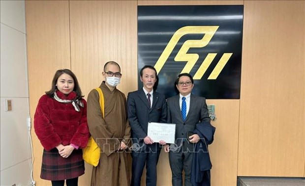  Le représentant du comité de mobilisation de fonds a présenté le don au représentant en chef d'Ishikawa. Photo : VNA.