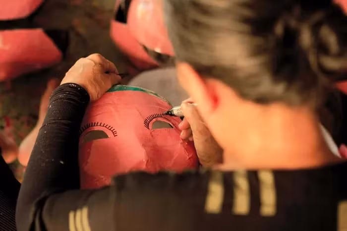 Le masque, après avoir été enduit de papier mâché et séché, est peint et décoré avec des formes d'animaux amusants.