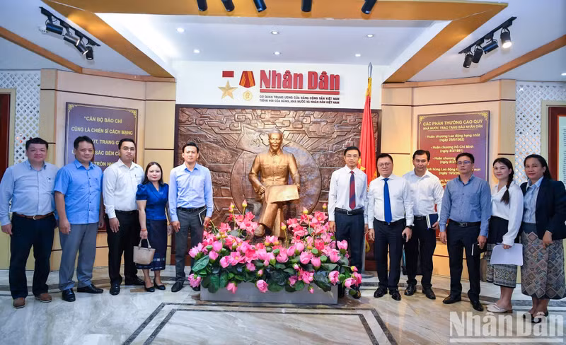 Les dirigeants du journal Nhan Dan et la délégation de Pasaxon posent pour une photo souvenir à la Maison d’exposition de Nhan Dan. Photo : Thanh Dat.