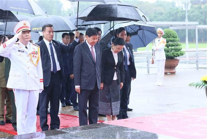 Le secrétaire général du Parti populaire révolutionnaire lao et président du Laos Thongloun Sisoulith et son épouse, accompagnés d'une délégation de haut rang du Parti et de l'État du Laos, rend hommage au Président Hô Chi Minh en son mausolée. Photo : VNA.