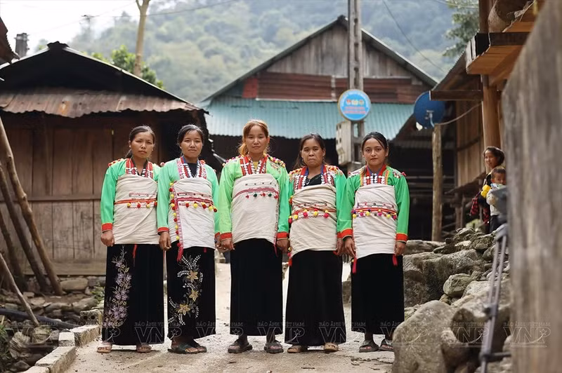 La particularité des costumes des femmes Mảng est la cape en tissu brut blanc, brodée de fil rouge et enroulée autour du corps.