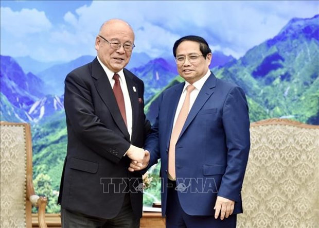 Le Premier ministre Pham Minh Chinh (à droite) serre la main du conseiller spécial de l’Alliance parlementaire d’Amitié Japon - Vietnam, Takebe Tsutomu, à Hanoi, le 14 mars. Photo : VNA.