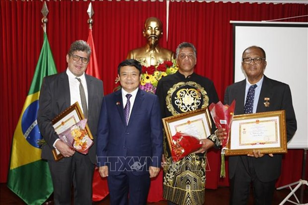 L'ambassade du Vietnam au Brésil, Bùi Van Nghi (2e, gauche) remet l’insigne “Pour la paix et l'amitié entre les peuples” de l'Union des Organisations d'amitié du Vietnam à Miguel Peña, consul honoraire du Vietnam en Bolivie, João Reis, consul honoraire du Vietnam dans l'État du Minas Gerais (Brésil), et à Valter Xéu, PDG du groupe Patria Latina Media. Photo : VNA.
