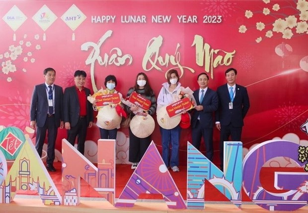 Des représentants du Service du Tourisme de Dà Nang et de l’aéroport de Dà Nang offrent des fleurs et cadeaux à des passagers du vol VZ964. Photo : VNA.
