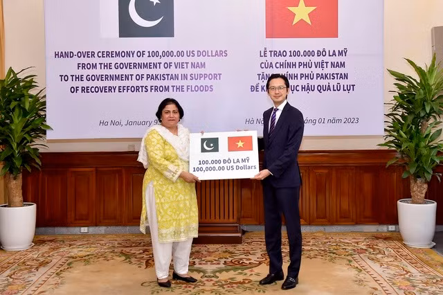 Le vice-ministre des Affaires étrangères, Dô Hùng Viêt, remet un montant symbolique de 100 000 dollars à l’ambassadrice du Pakistan, Samina Mehtab. Photo : VGP.
