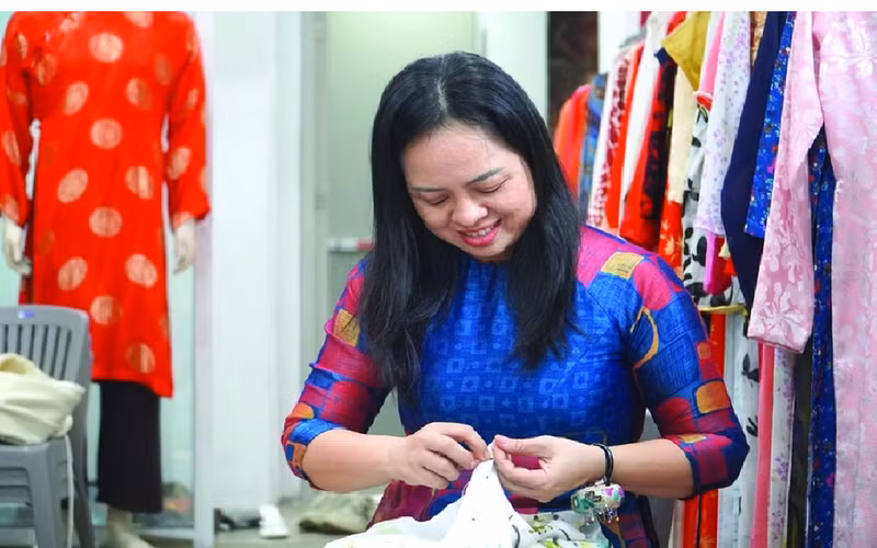 Doan Thi Nguyet ajusté un ao dai. Photo : https://phunuvietnam.vn/