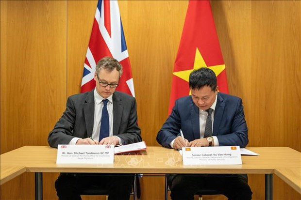 Le directeur adjoint du département de l’immigration du ministère vietnamien de la Sécurité publique, Vu Van Hung (à droite) et le ministre britannique chargé de la lutte contre l’immigration clandestine, Michael Tomlinson, signe la déclaration commune de coopération. Photo : VNA