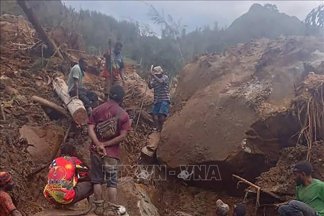 Des personnes fouillent les débris sur le site d’un glissement de terrain, dans la province d’Enga, en Papouasie-Nouvelle-Guinée, le 26 mai. Photo : VNA