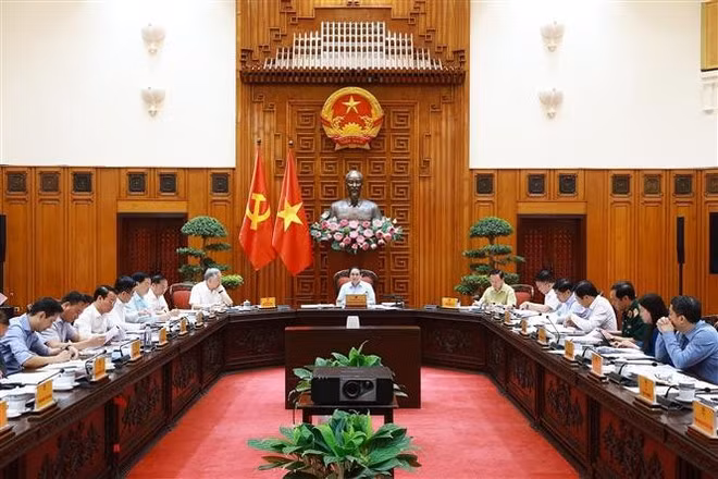 Le Premier ministre Pham Minh Chinh (centre) lors de la réunion, à Hanoi, le 22 avril. Photo : VNA.