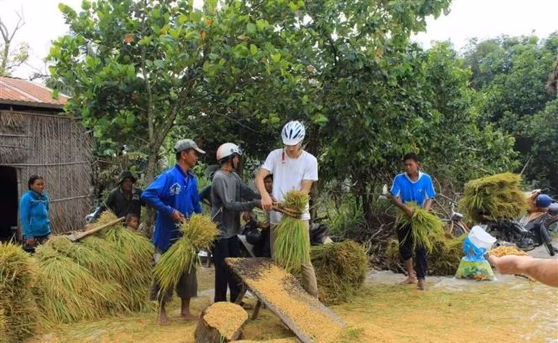 Un touriste étranger découvre le travail agricole à An Giang. Photo : VNA. 