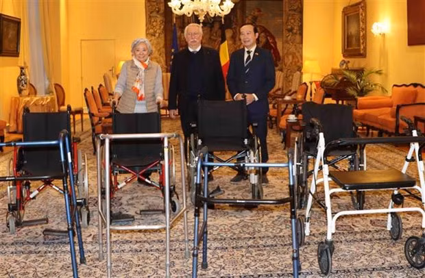 Le député fédéral belge André Flahaut (au milieu) remet quatre fauteuils roulants et quatre déambulateurs à l'ambassadeur du Vietnam en Belgique, Nguyên Van Thao. Photo : VNA.