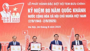 Les délégués signent la couverture d’émission spéciale du bloc de timbres commémorant le 80e anniversaire de la Fête nationale et posent pour une photo souvenir.