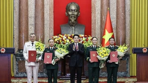 Le président Luong Cuong remet les décisions de promotion au grade de général de corps d’armée à quatre officiers supérieurs de l’Armée et de la Police populaires du Vietnam. Photo : NDEL.