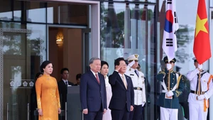 Le président sud-coréen Lee Jae Myung et son épouse, aux côtés du secrétaire général To Lam et de son épouse, occupent la tribune d’honneur pour écouter l’hymne national des deux pays joué par la fanfare militaire. Photo : VNA.