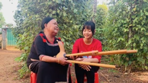 L'artiste H'Bliư̆ Hwing enseigne à sa petite-fille H Lana le chant « eirei » et à jouer du « đinh năm », Photo : VOV.