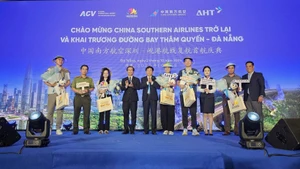 Des représentants des dirigeants offrent des cadeaux aux premiers passagers du vol Shenzhen-Da Nang. Photo : https://congly.vn/