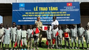 Le Lieutenant-colonel Trần Thanh Sơn, Commandant adjoint de l'unité de génie no 4, remet des fournitures scolaires aux élèves d'Abyei. Photo : Hai Yen.