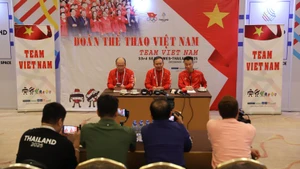 Le chef de délégation, Nguyên Hôngg Minh (assis au centre), et ses deux adjoints président la réunion. Photo : VNA.