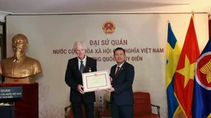 L'ambassadeur Trần Văn Tuấn remet la médaille pour la cause de la culture, des sports et du tourisme au réalisateur de cinéma Bo Öhlén. (Photo: Ambassade du Vietnam en Suède)