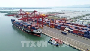 Un navire partenaire réceptionne un conteneur au poste d'amarrage n° 2 du port international de Chu Lai. Photo : VNA